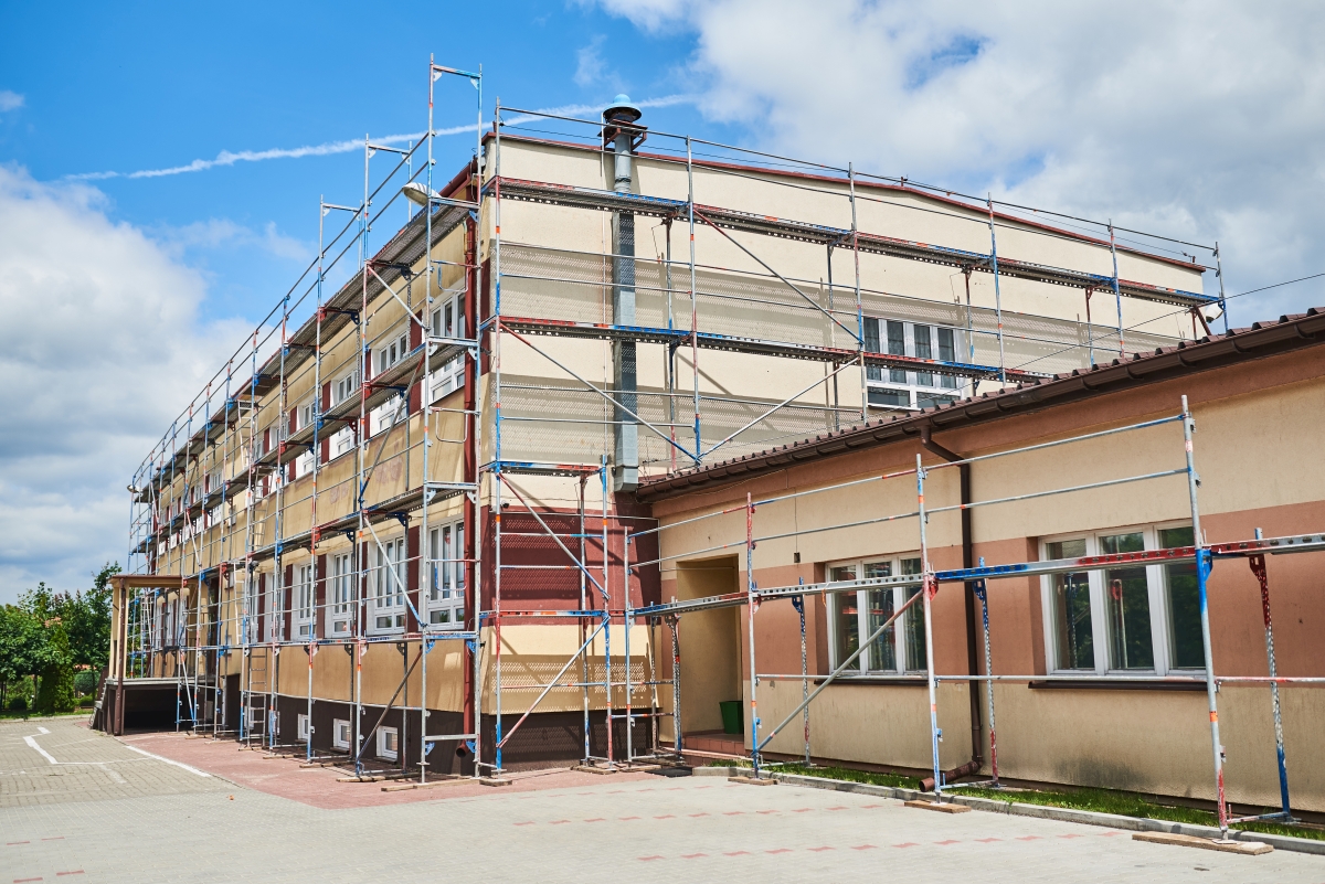 Grafika przedstawia zdjęcie budynku szkoły podstawowej w Skrzyńsku w czasie prac remontowych